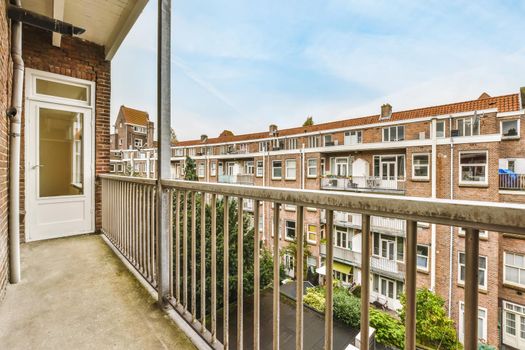Graceful balcony with a unique view of multi-storey brick houses