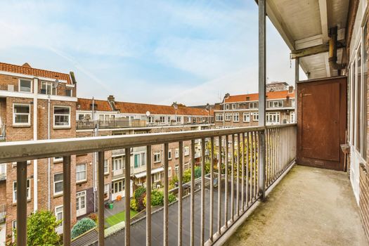Graceful balcony with a unique view of multi-storey brick houses