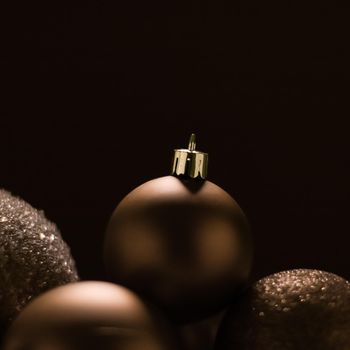 Christmas holiday and festive decoration concept. Golden baubles on beige background.