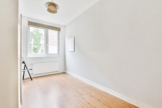 Small cozy room with a small window and a wooden floor