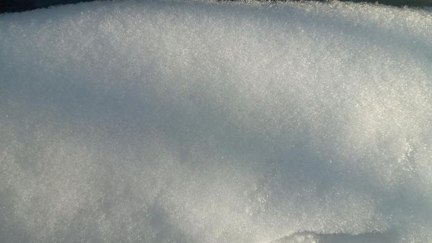 Background with natural snow texture, close-up from above. Shadow in the form of straight lines on a snowy surface, abstract background.