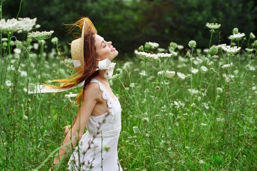 Woman in white dress and hat in a field with flowers lifestyle. High quality photo
