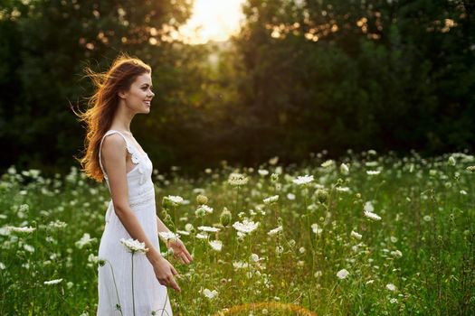 Woman in white dress in a field flowers sun nature freedom. High quality photo