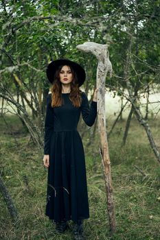 woman in black suit Witch in a fantasy forest. High quality photo