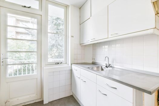 Miniature kitchen in white tones and a window on one side