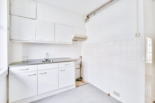Miniature kitchen in white tones and a window on one side