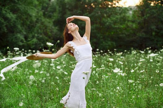 cheerful woman in a field outdoors flowers fresh air freedom. High quality photo