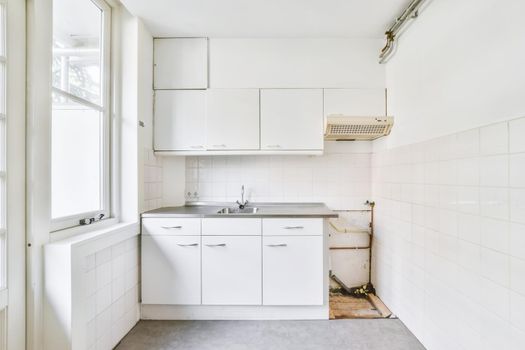 Miniature kitchen in white tones and a window on one side
