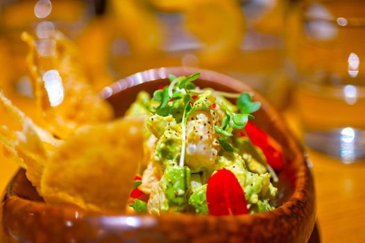 fresh avocado and shrimps salad with nachos on side