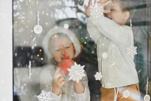 The kids looking at snowflakes on a window