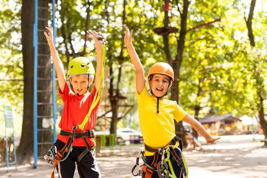 Happy child climbing in the trees. Rope park. Climber child. Early childhood development. Roping park. Balance beam and rope bridges. Rope park - climbing center.