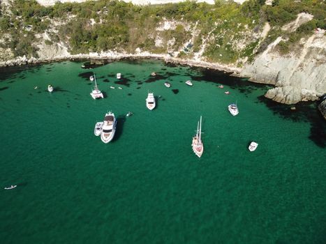 Sea landscape with rocky coastline on sunset time with cloudy sky. Yachts in the Sea on a background of rocky shores. The concept of perfect place for summer travel and rest.