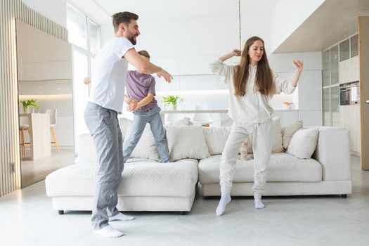 Family have fun dancing at home in living room. Happy family spend time together concept