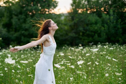 Woman in white dress in a field of flowers walk freedom. High quality photo
