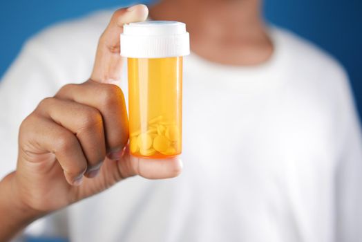 young man hand holding medicine pill container .