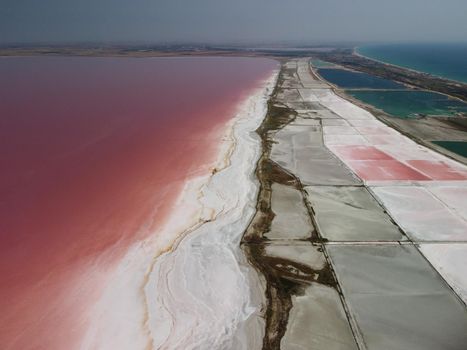 Aerial drone footage of a pink salt lake on a beautiful summer evening. Aerial view of a dried pink salt lake on a beautiful summer evening. Aerial view of a drying out salt lake.