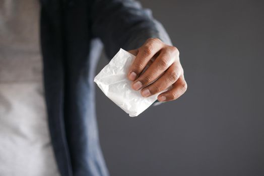 drug addiction concept with hand holding heroine packet on black backgrund.