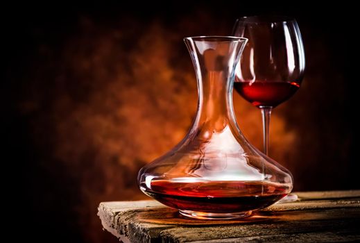 Wine in a decanter and glass on a wooden table