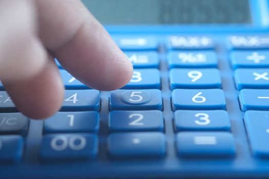 Close up of man hand using calculator.