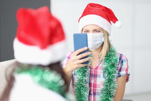 Portrait of woman take video of friend on smartphone, content for internet channel. Celebrating new year with friend during quarantine. Friendship concept