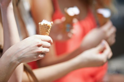Hands of girlfriends eating ice cream