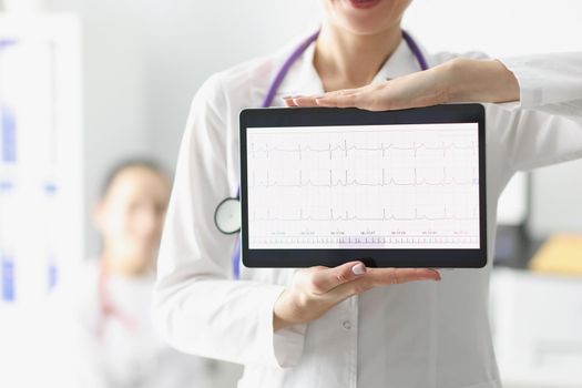 Close-up of doctor showing digital tablet screen with heart cardiogram result. Examination of cardiovascular system. Medicine, cardiology, health concept