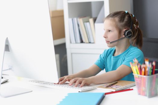 Portrait of girl busy with online school classes from home because of pandemic situation. Child wear headset for better result. Distance education concept
