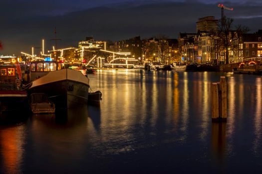 Amsterdam by night with the illuminated Tiny Bridge at the Amstel in the Netherlands at christmas