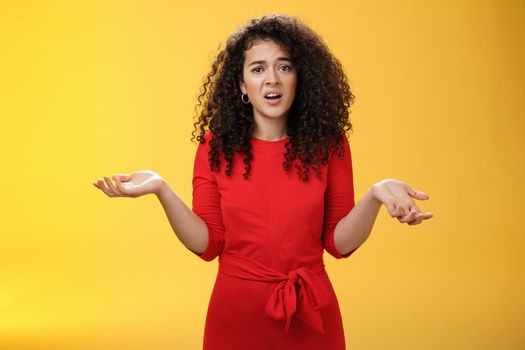 What your problem. Annoyed and confused pissed girlfriend with curly hair in elegant party dress shrugging with hands spread sideways and clueless grimace, waiting explanation during argument.