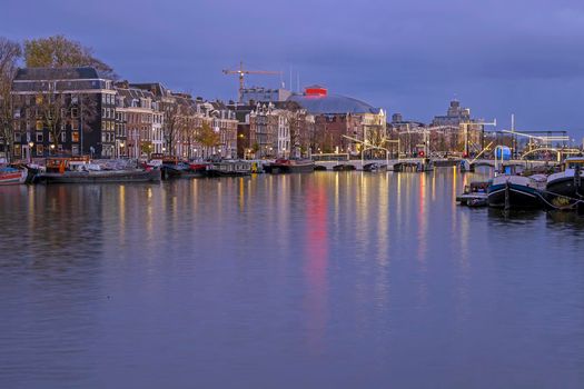 City scenic from Amsterdam at the river Amstel in the Netherlands at sunset