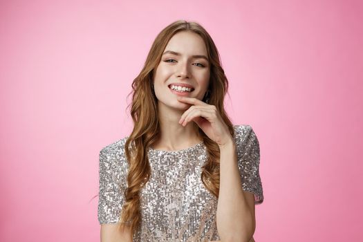 Flirty sensual attractive caucasian party girl wearing fashioable shiny blouse raise head arrogant smiling delighted coquettish, seducing you grinning satisfied confident, standing pink background.