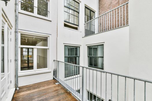 Cozy pretty balcony with comfortable railings and wooden floor