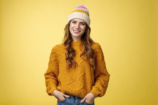 Outgoing stylish friendly-looking female employee tilting head smiling pleasant hold hands pockets jeans self-assured, expressing confidence determined reach success, yellow background.