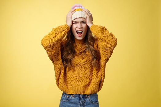 Pissed annoyed freaked-out girlfriend jealous screaming pissed insane caught boyfriend cheating hold hands head shouting angry frowning cringing disgust dissatisfied look camera, yellow background.