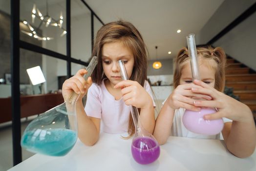 Girls making chemical experiments at home, close view.