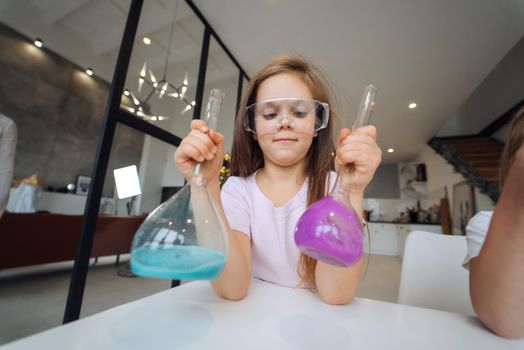 Girl making chemical experiments at home, close view.