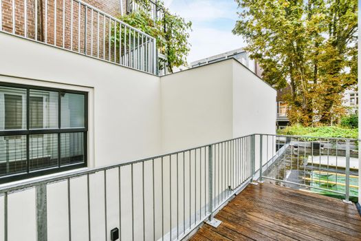 Cozy pretty balcony with comfortable railings and wooden floor