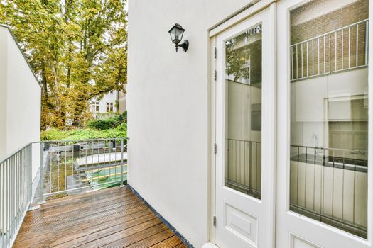 Cozy pretty balcony with comfortable railings and wooden floor