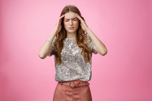 Caucasian woman feeling dizzy drink too much alcohol party, touching temples close eyes frowning suffering headache feeling discomfort, migraine, standing displeased unwell pink background.