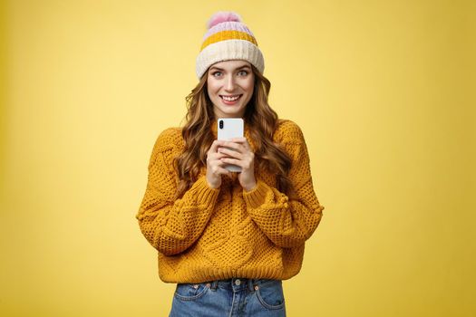 Smiling friendly-looking charming young trendy girlfriend holding brand new smartphone satisfied smiling upbeat receiving mobile phone birthday present grinning satisfied, taking photo you.