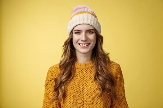 Attractive young friendly-looking outgoing girl dressed warm travel mountains skiing having fun spend winter holidays alps family, smiling broadly wearing corduroy hat sweater, yellow background.