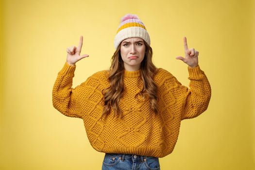 Upset whining complaining displeased cute young immature girl raise hands pointing up crying jealous regret wanna buy cool product have no money, standing sad sobbing yellow background.