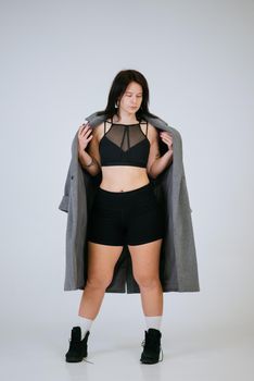 Plus size body positive woman wearing comfortable underwear and coat