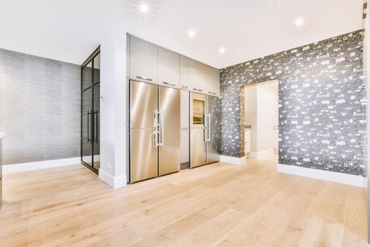 A wide apartment covered with brown wallpaper and with refrigerator