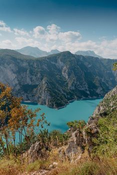 The concept of eco-tourism and active recreation. National Park. Mountain Emerald lake in the wooded mountains. Sunny day in autumn.