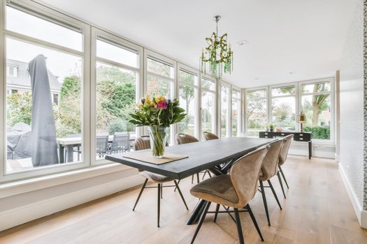 Large dining room with large table and chairs and a full side wall window