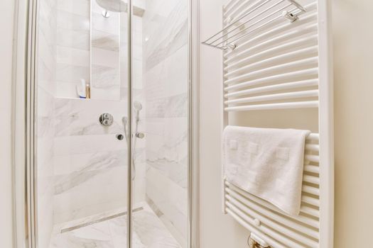 Bright shower cubicle with a radiator and a towel on it