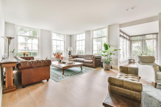 Luxurious living room with soft sofa and armchairs