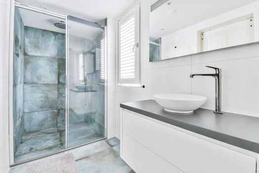 Stylish bathroom with large marble tiles on the walls and floor