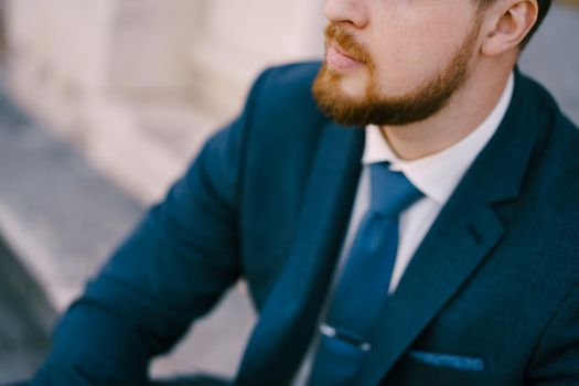 Man in a blue suit and tie with a beard and mustache. Close-up. High quality photo